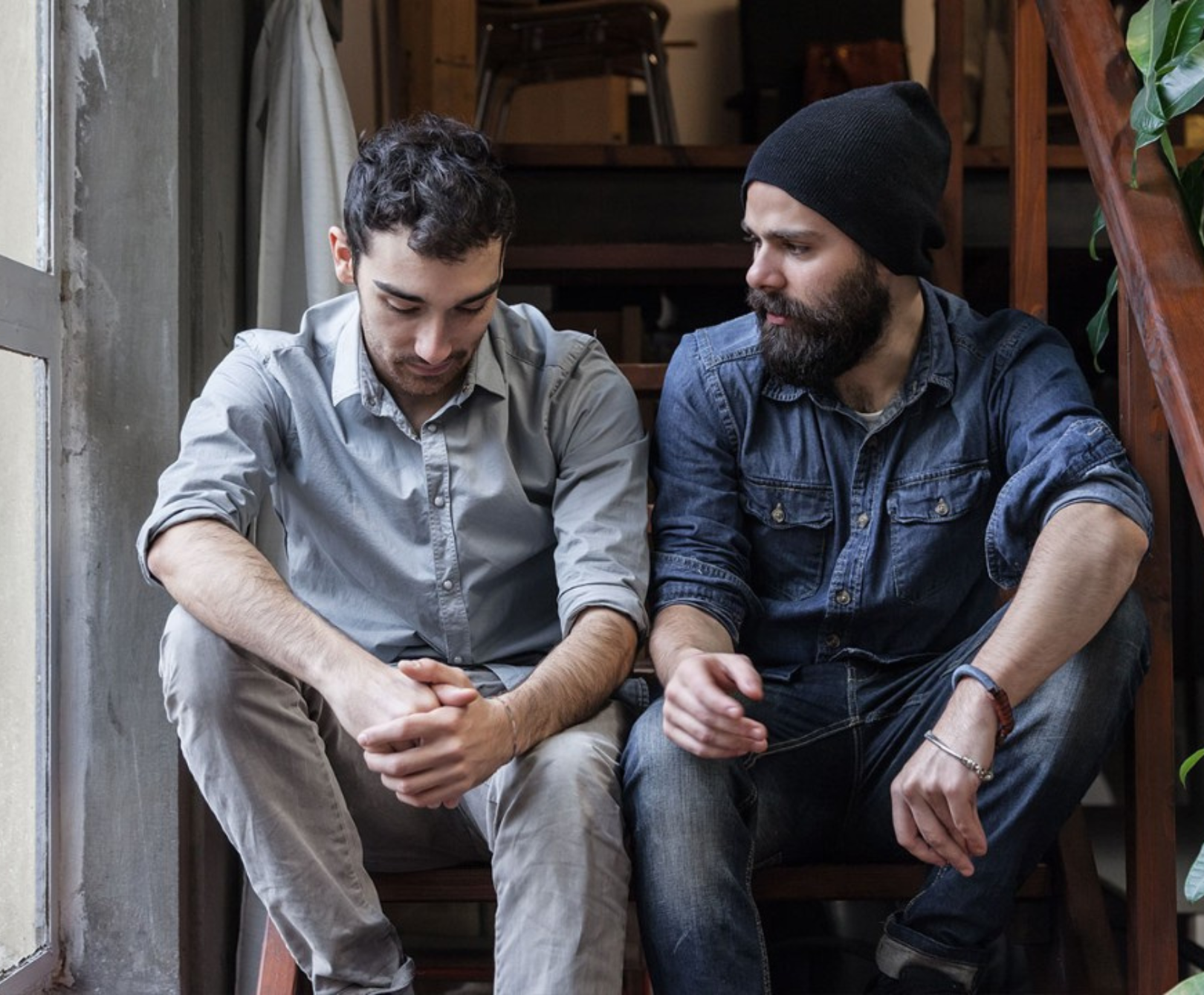 Two men sitting on a staircase

Description automatically generated